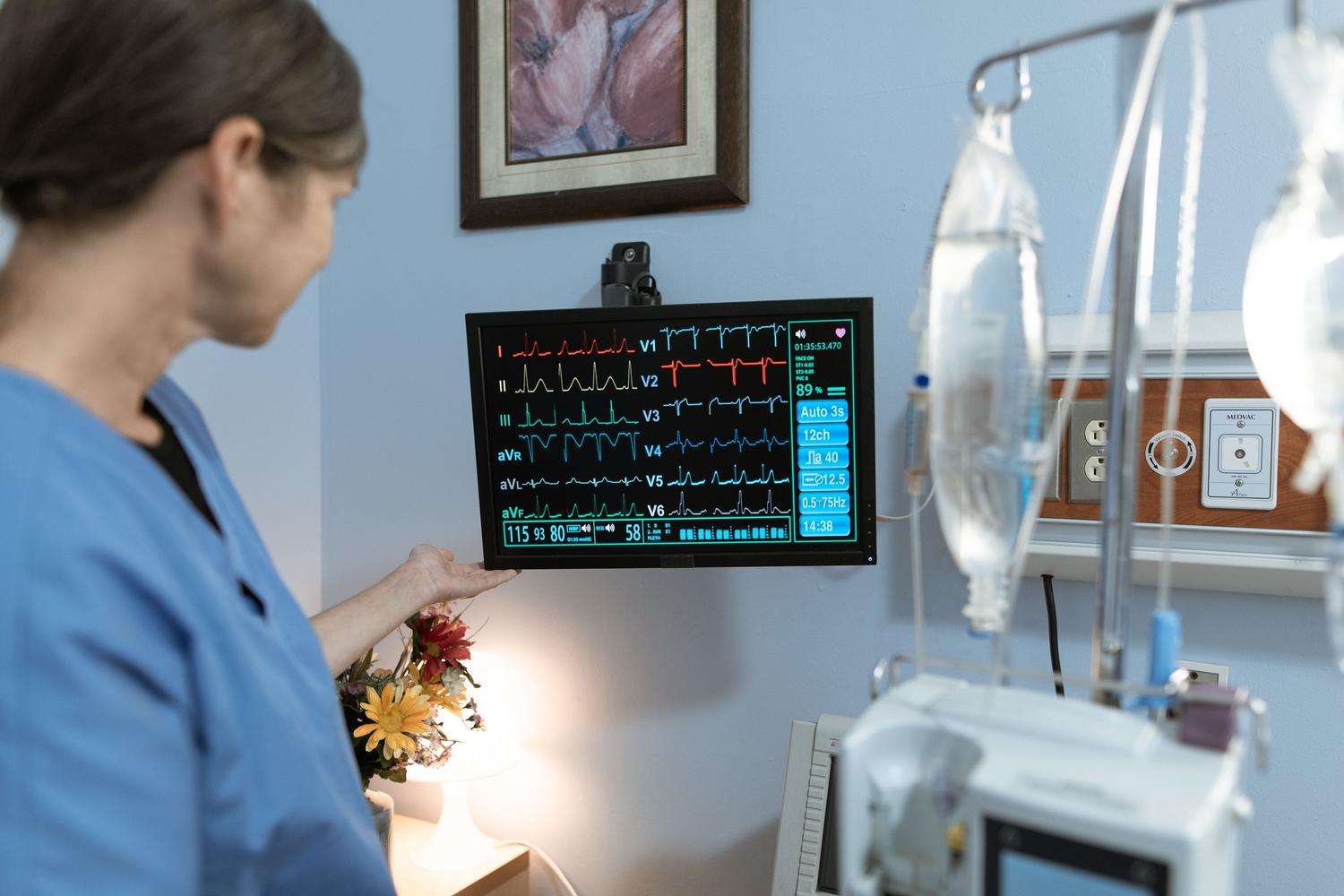 Profesional de la salud monitorizando las constantes vitales de un paciente en una pantalla en el quirófano.