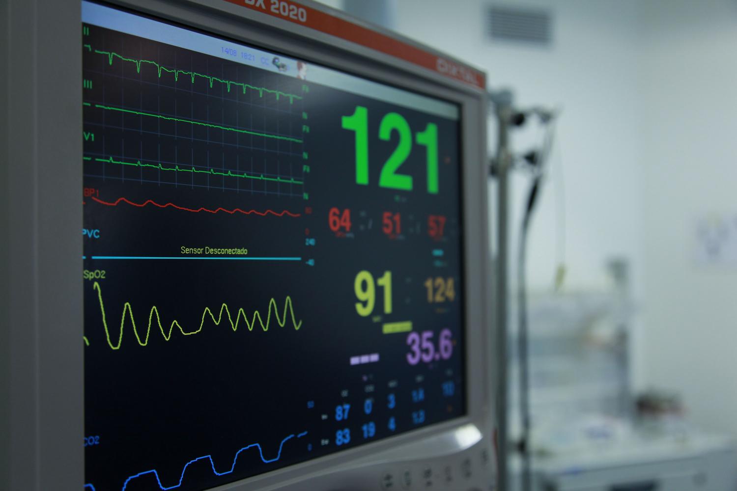 Primer plano de un monitor de constantes vitales en hospital, simbolizando la recolección de datos para el riesgo nutricional
