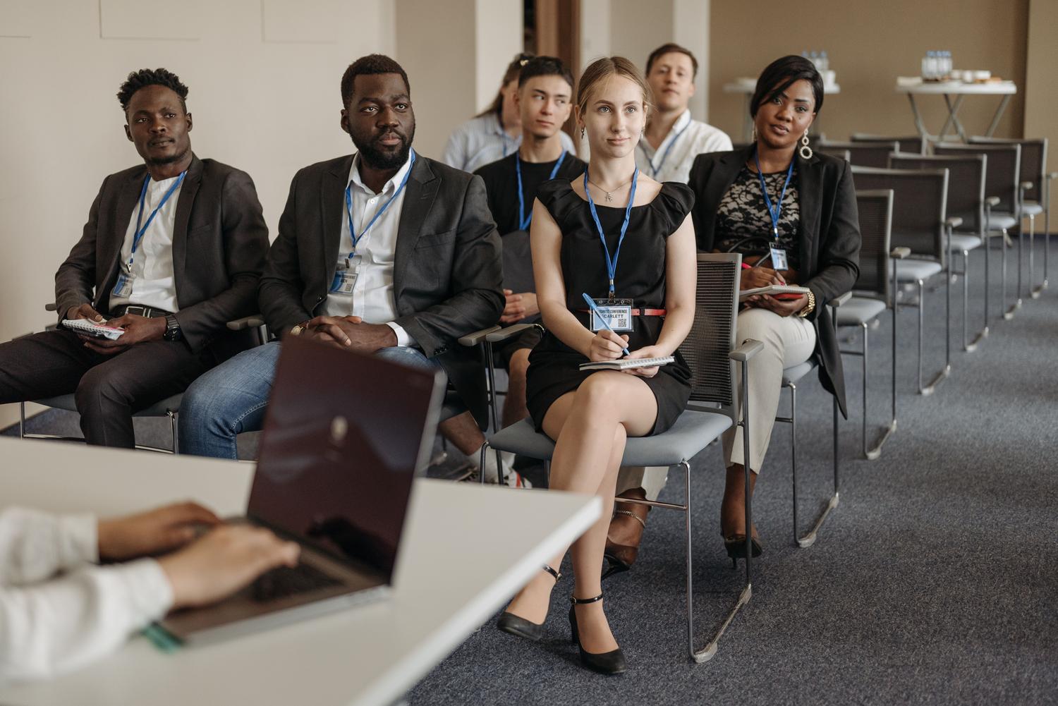 Profesionales de negocios asistiendo a una conferencia de formación, representando el enfoque práctico y profesional del máster propio.