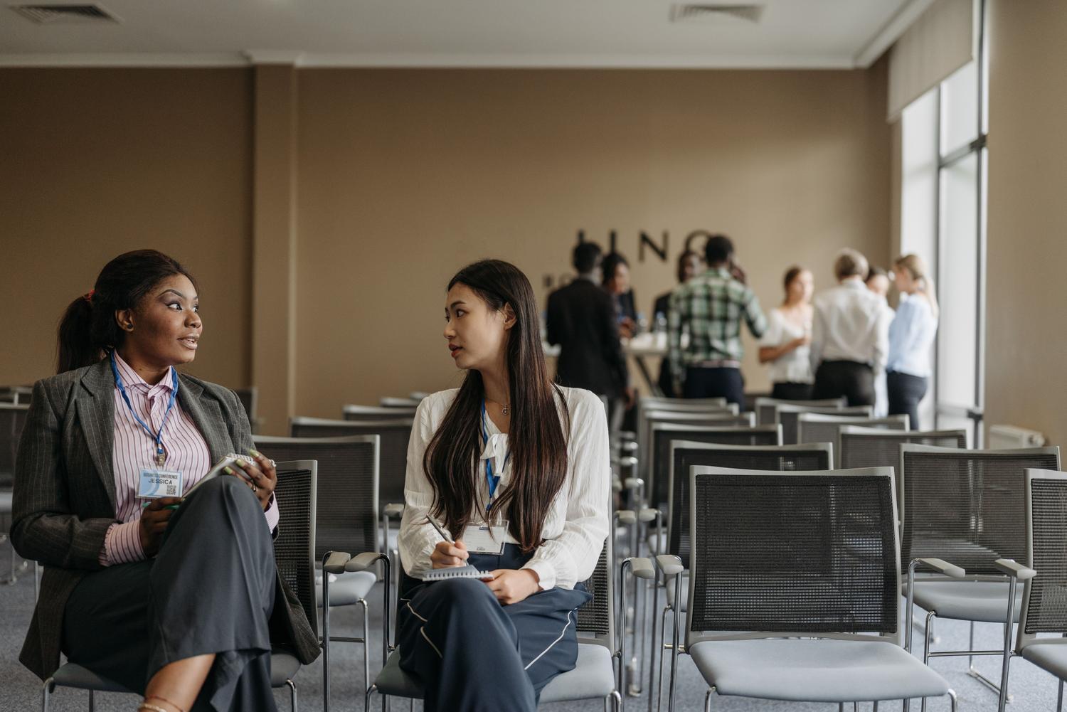 Dos profesionales haciendo networking em un evento empresarial, destacando una de las principales ventajas do máster próprio.