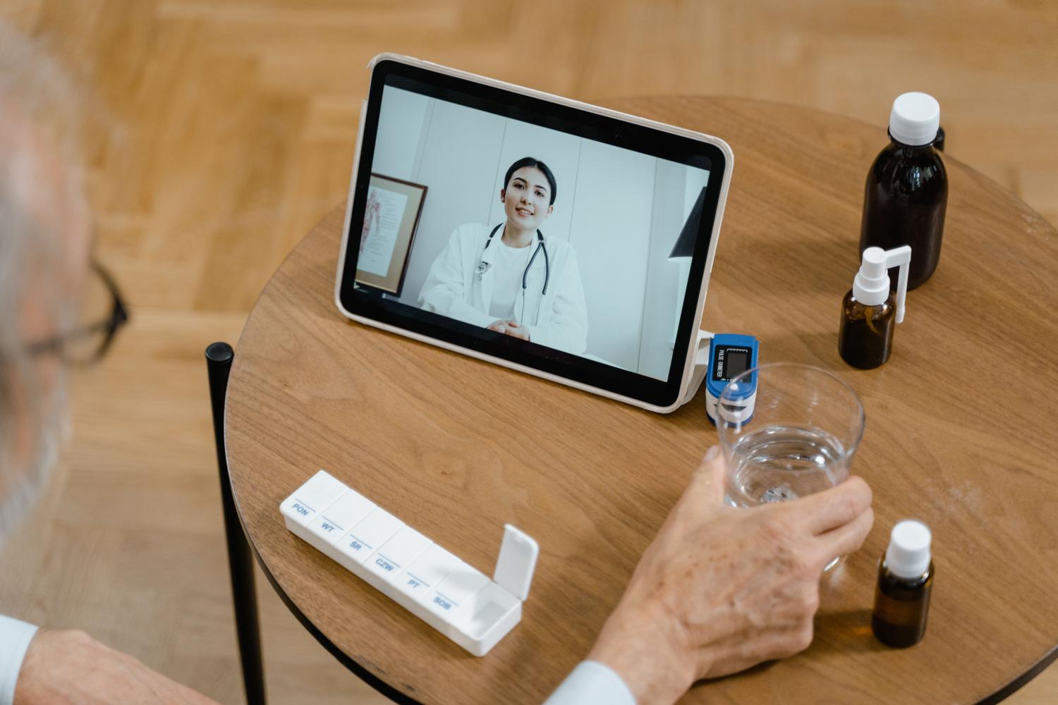 Persona mayor realizando uma consulta médica virtual mediante una tablet, ejemplificando la telemedicina y el cuidado de la salud en el hogar.