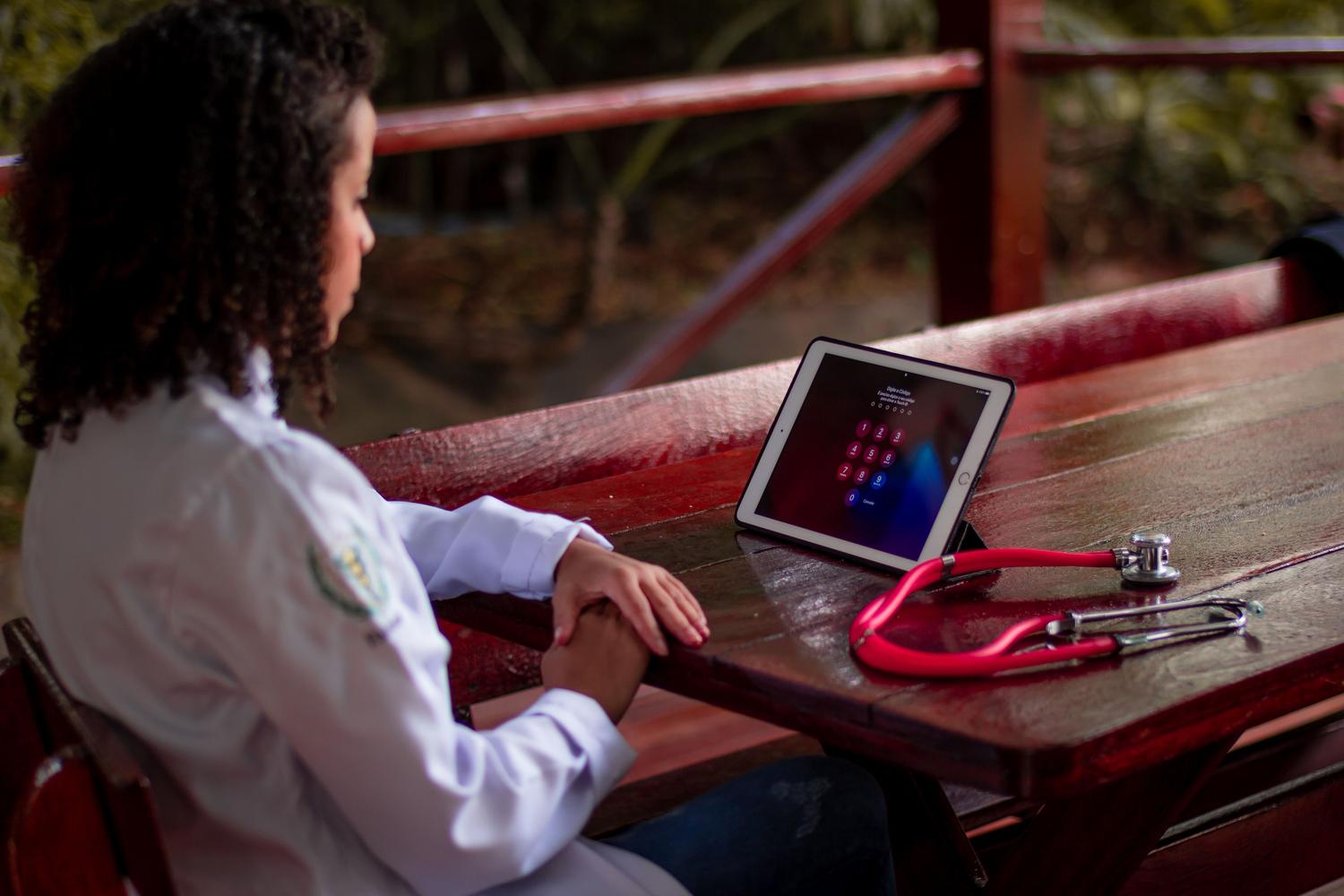 Profesional sanitario utilizando una tablet junto a un estetoscopio, representando la integración de herramientas digitales en la medicina preventiva.