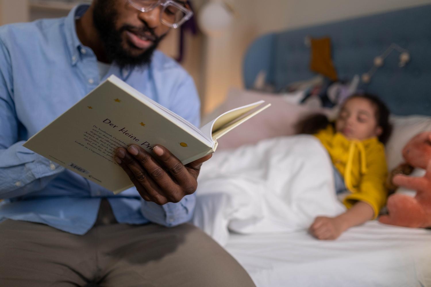 Un padre leyendo un cuento antes de dormir a su hija en la cama, destacando la importancia de las rutinas de higiene del sueño.