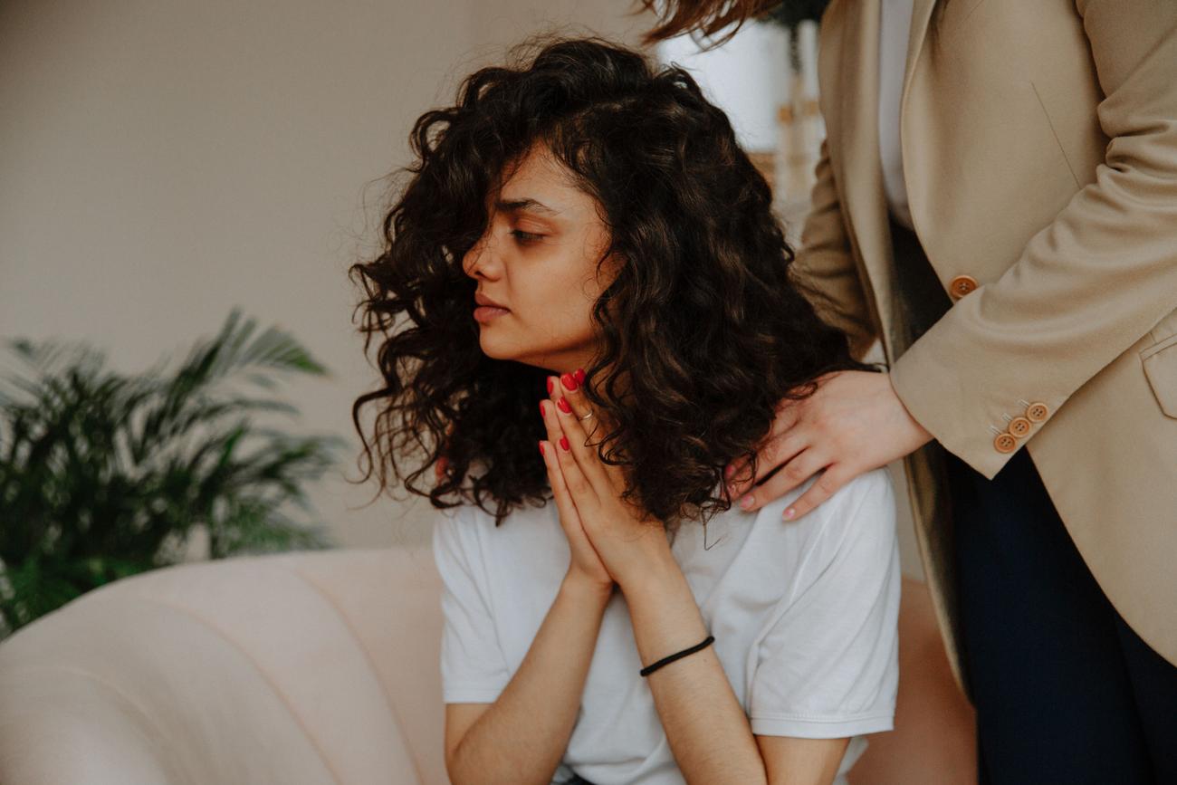 Uma mulher jovem recebendo consolo e apoio profissional durante uma sessão de terapia psicológica em um ambiente tranquilo.