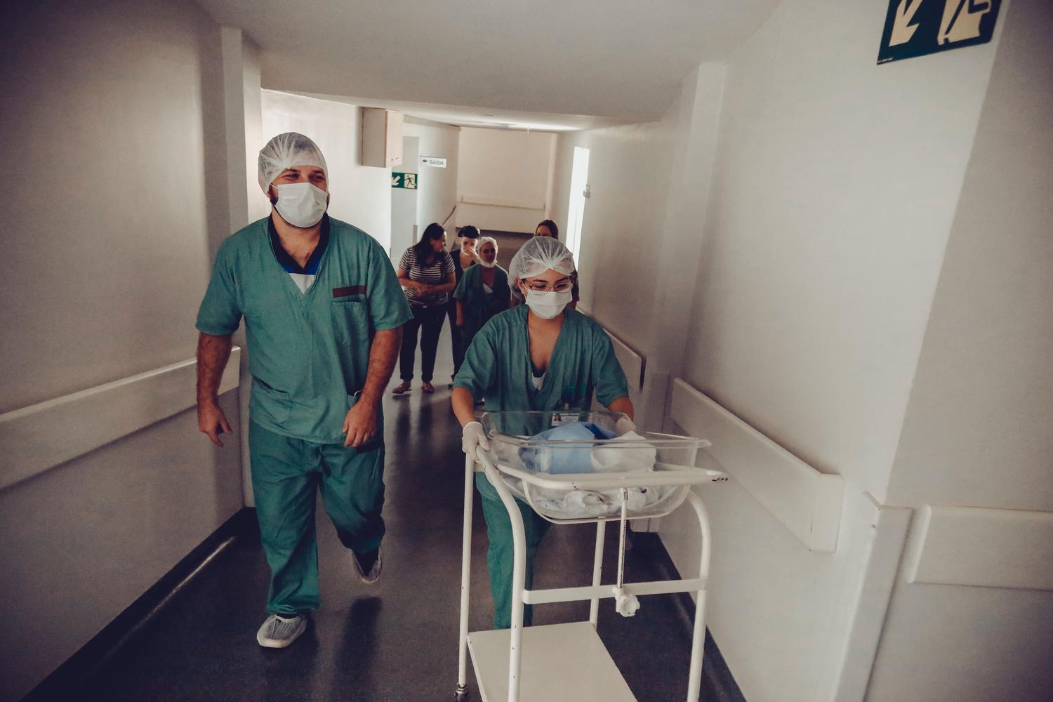 Personal de enfermería coordinando el traslado de un recién nacido en el hospital, mostrando la integración de roles para la seguridad del paciente.
