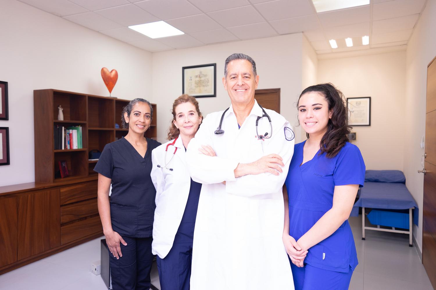 Profesionales de la salud de diversas especialidades colaborando en una clínica, destacando el trabajo en equipo multidisciplinar.