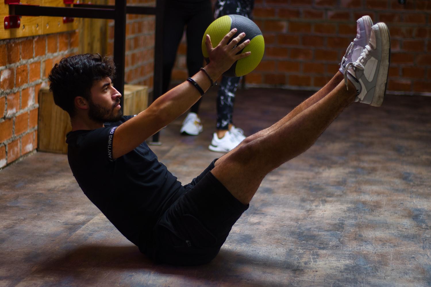 Homem realizando exercícios de força no ginásio, destacando a importância da atividade física no tratamento.