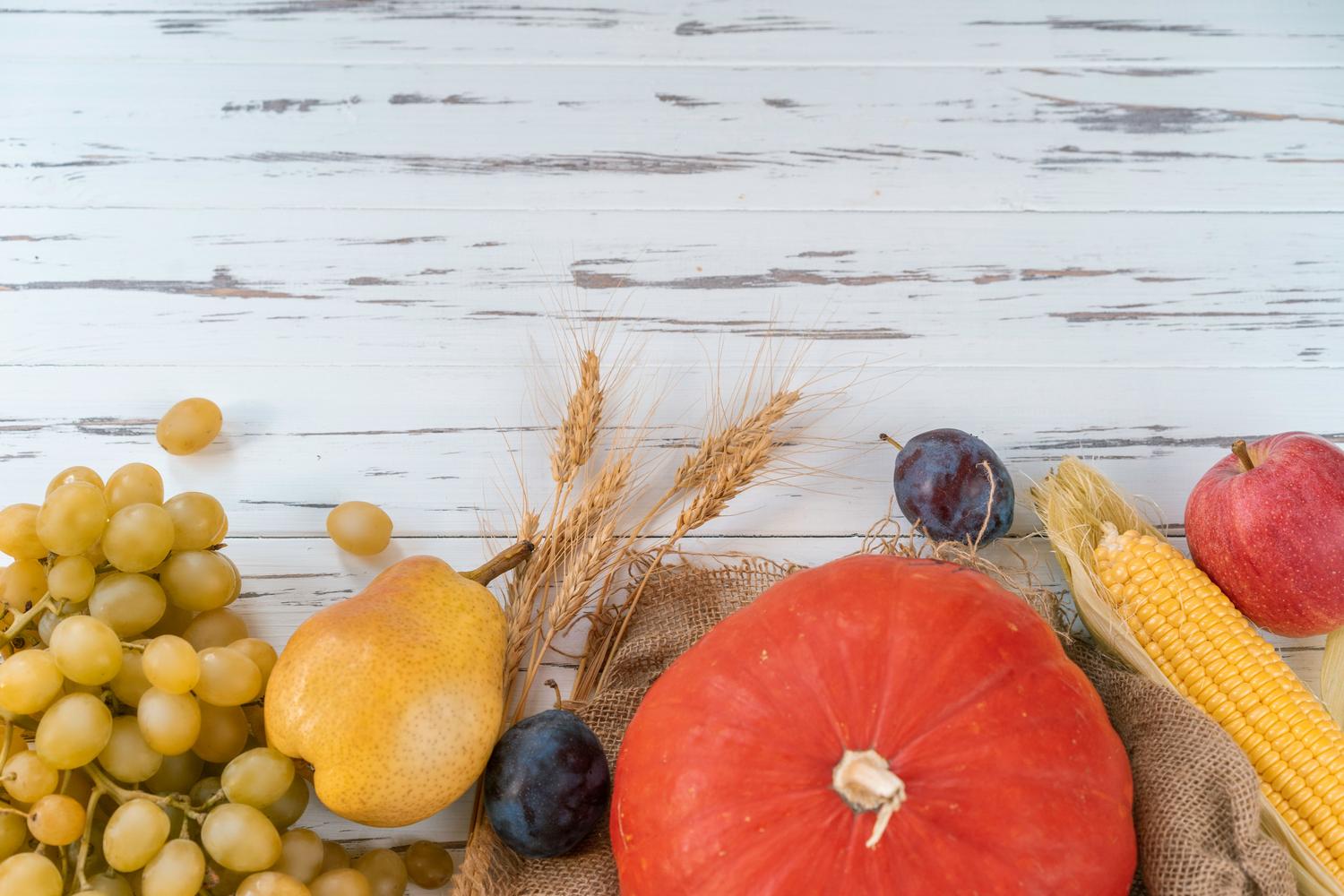 Variedad de frutas y verduras frescas sobre una mesa de madera, destacando los alimentos ricos en fibra para prevenir hemorroides.