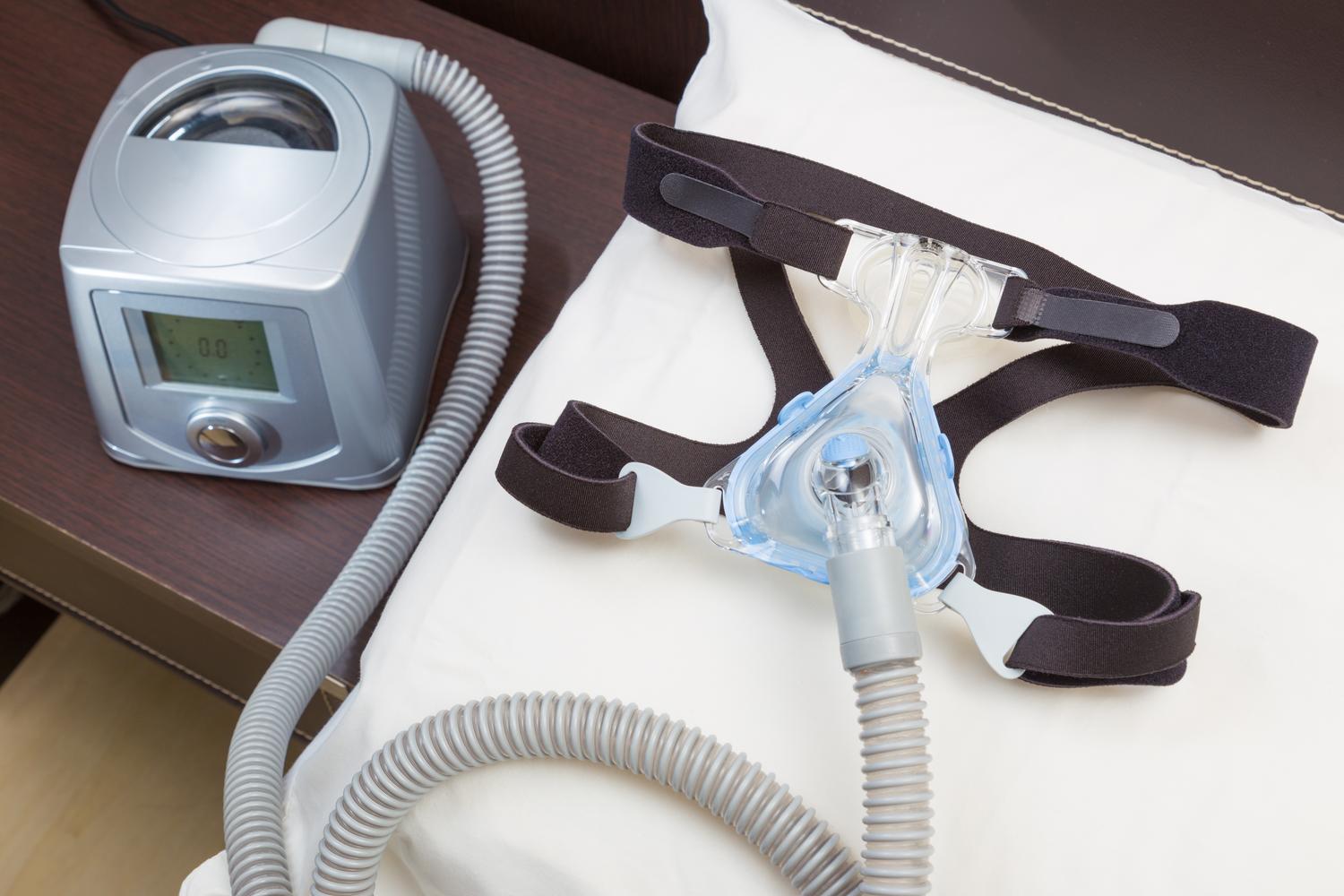 Detalle técnico de una máquina CPAP con su mascarilla y manguera, equipo fundamental para mantener las vías aéreas abiertas durante el sueño.