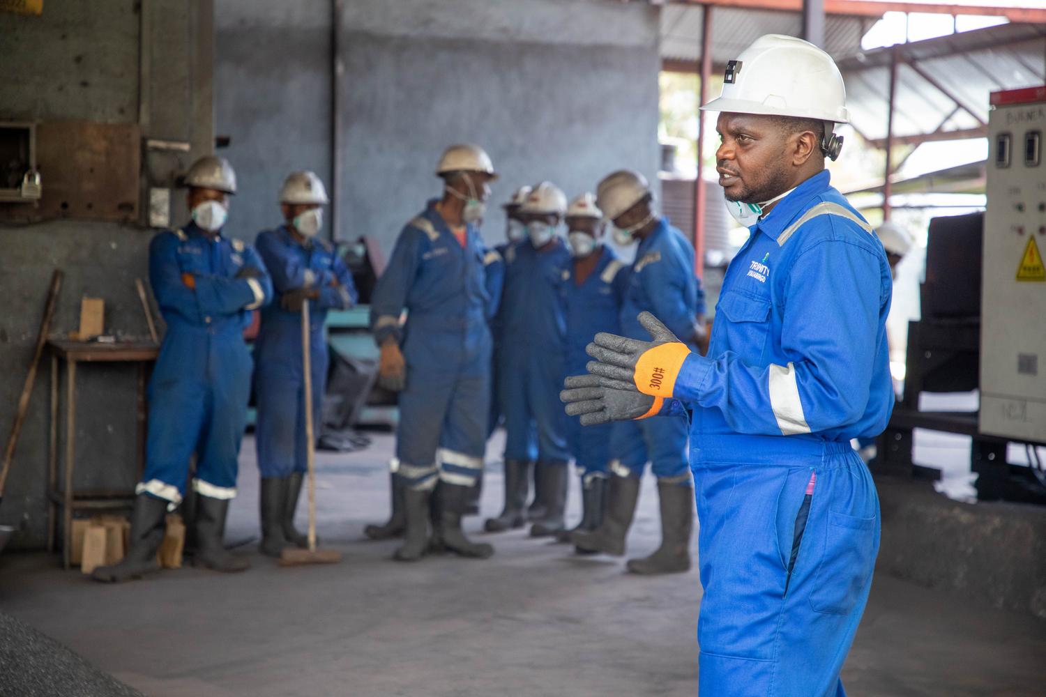 Trabajadores industriales con equipo de protección personal durante una sesión de formación, destacando la importancia de la prevención de riesgos en el entorno laboral.