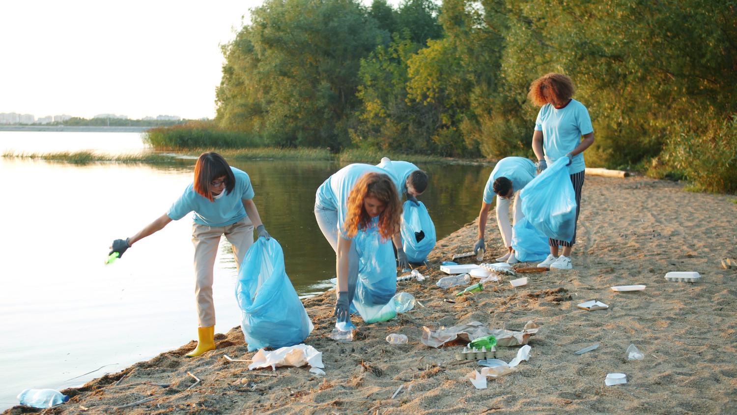 Grupo de voluntarios corporativos limpiando una playa, ilustrando el pilar ambiental de la Responsabilidad Social Corporativa.