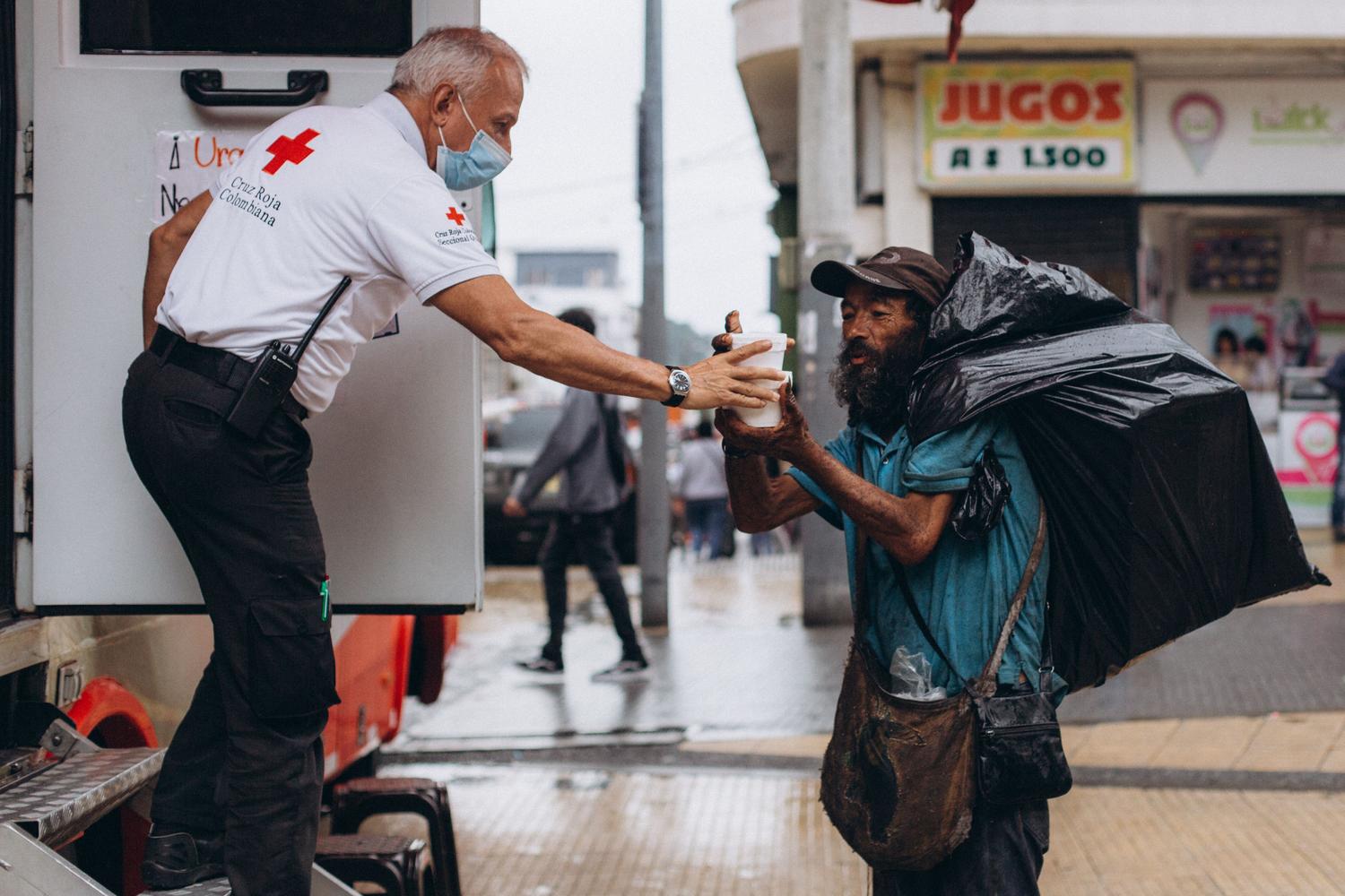 Un voluntario de la Cruz Roja brinda apoyo y ayuda humanitaria a una persona en situación de vulnerabilidad.