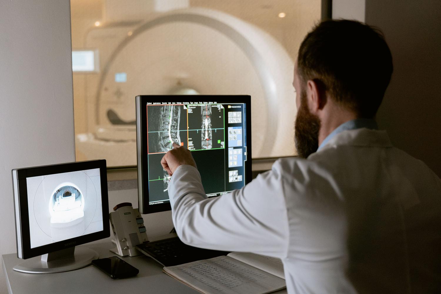 Especialista analizando resonancias magnéticas con software de precisión para la detección de biomarcadores