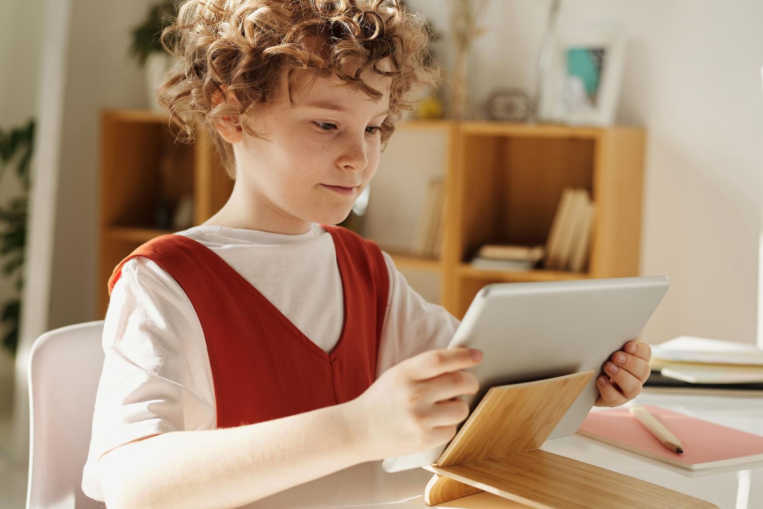 Niño pequeño utilizando uma tablet educativa en un entorno de aprendizaje temprano.