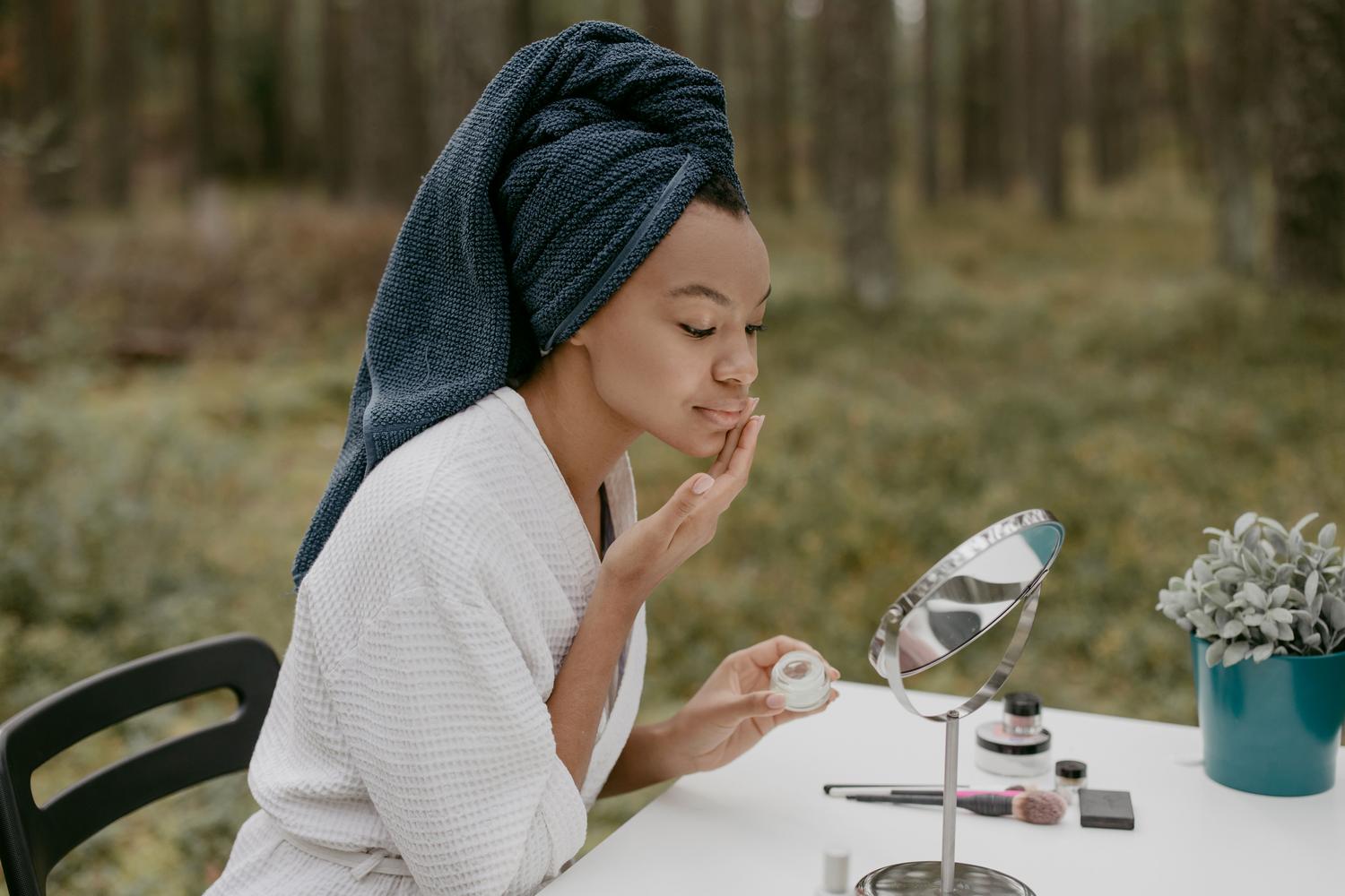 Mujer aplicándose crema hidratante ligera en un ambiente luminoso, ideal para pieles normales.