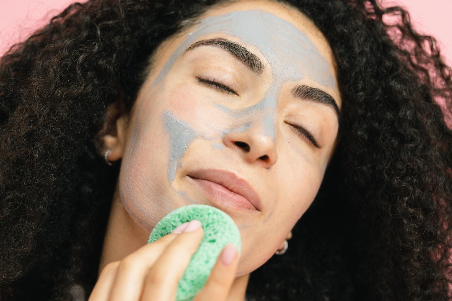 Mujer con mascarilla de arcilla purificante, tratamiento recomendado para pieles grasas y mixtas.