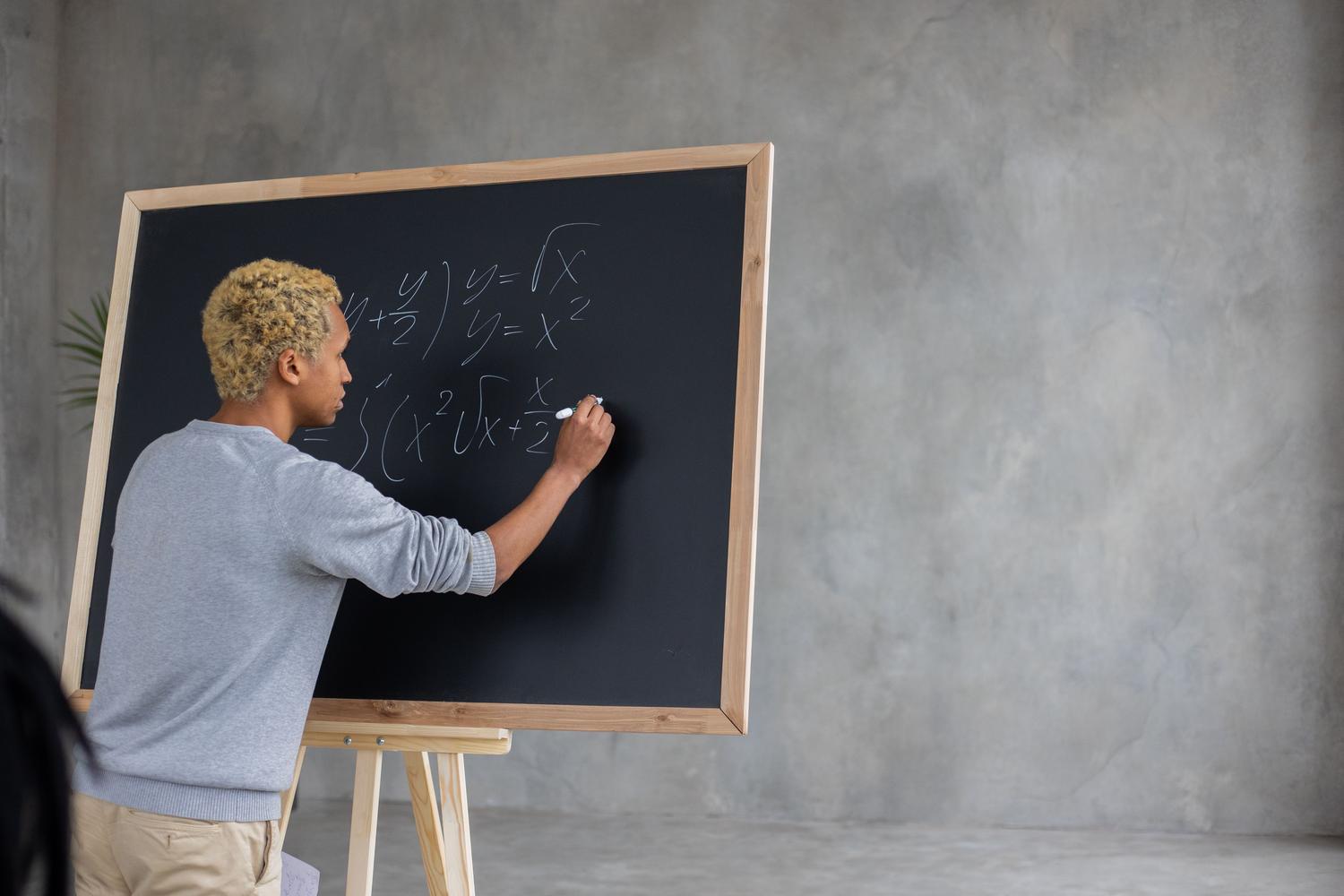 Estudiante resolviendo activamente ecuaciones matemáticas en una pizarra, representando la diversidad en STEM.