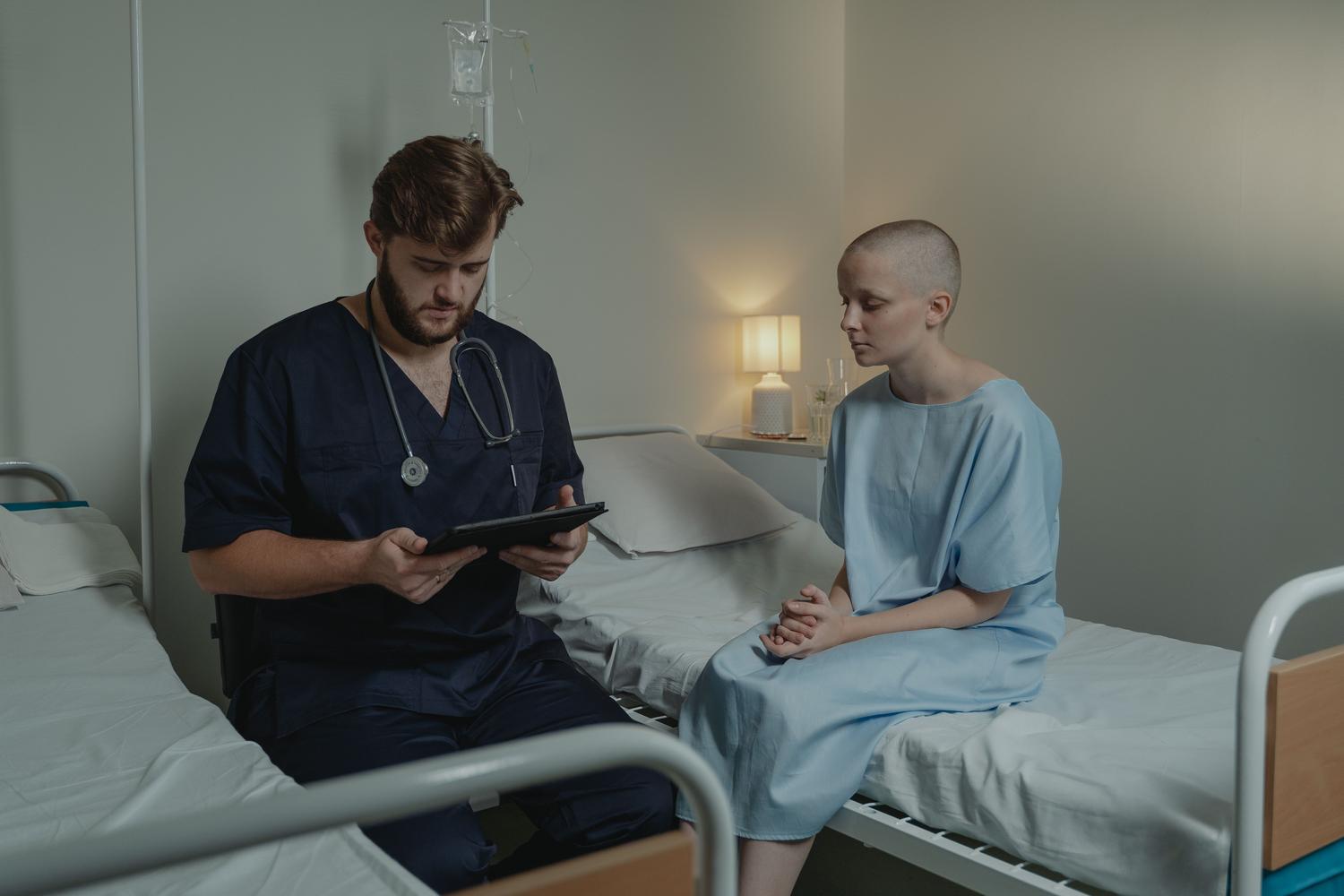 Oncólogo consultando a un paciente en el hospital mediante una tablet digital para coordinar el tratamiento de cáncer de vejiga