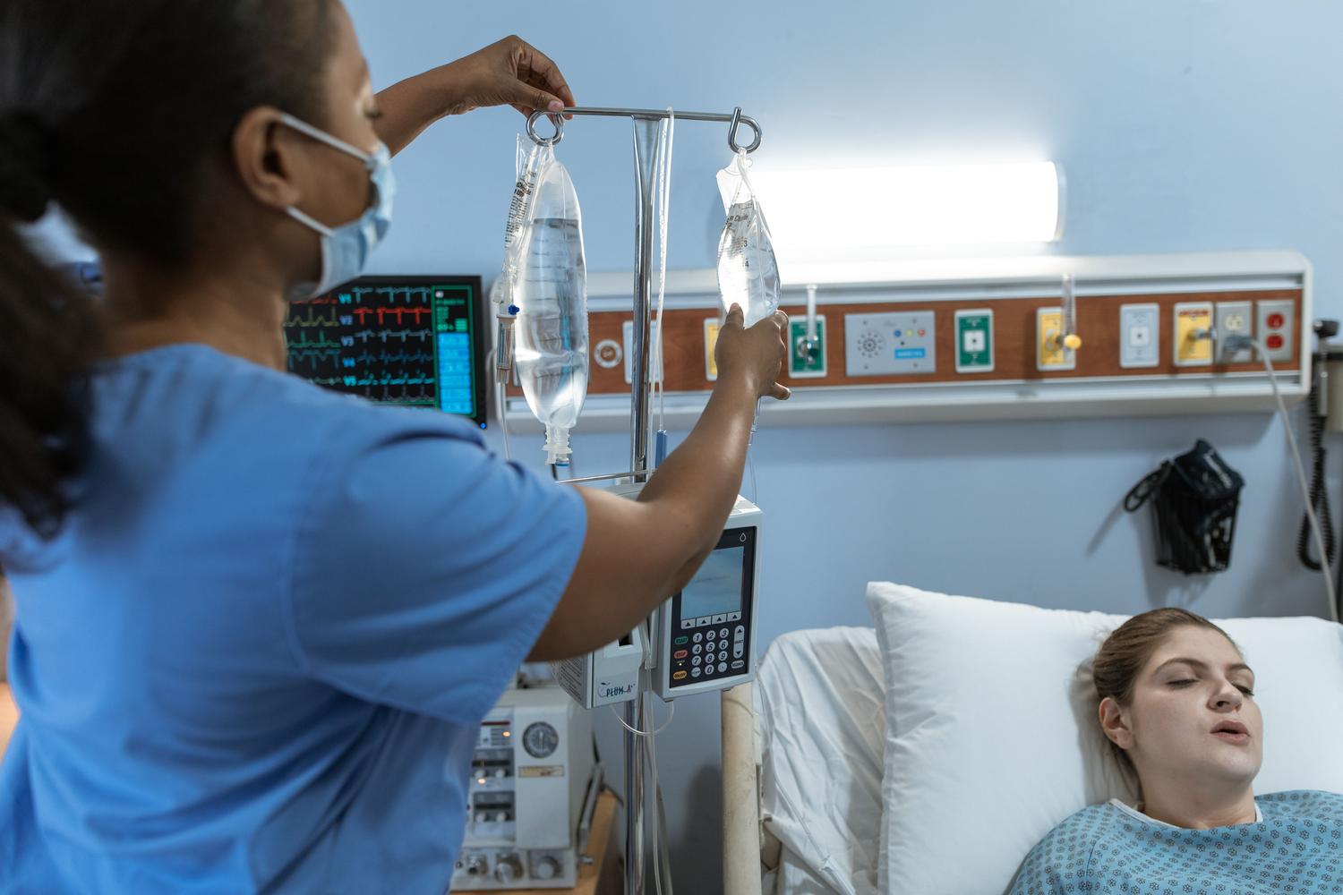 Enfermera ajustando el goteo de una infusión intravenosa de durvalumab en un entorno hospitalario