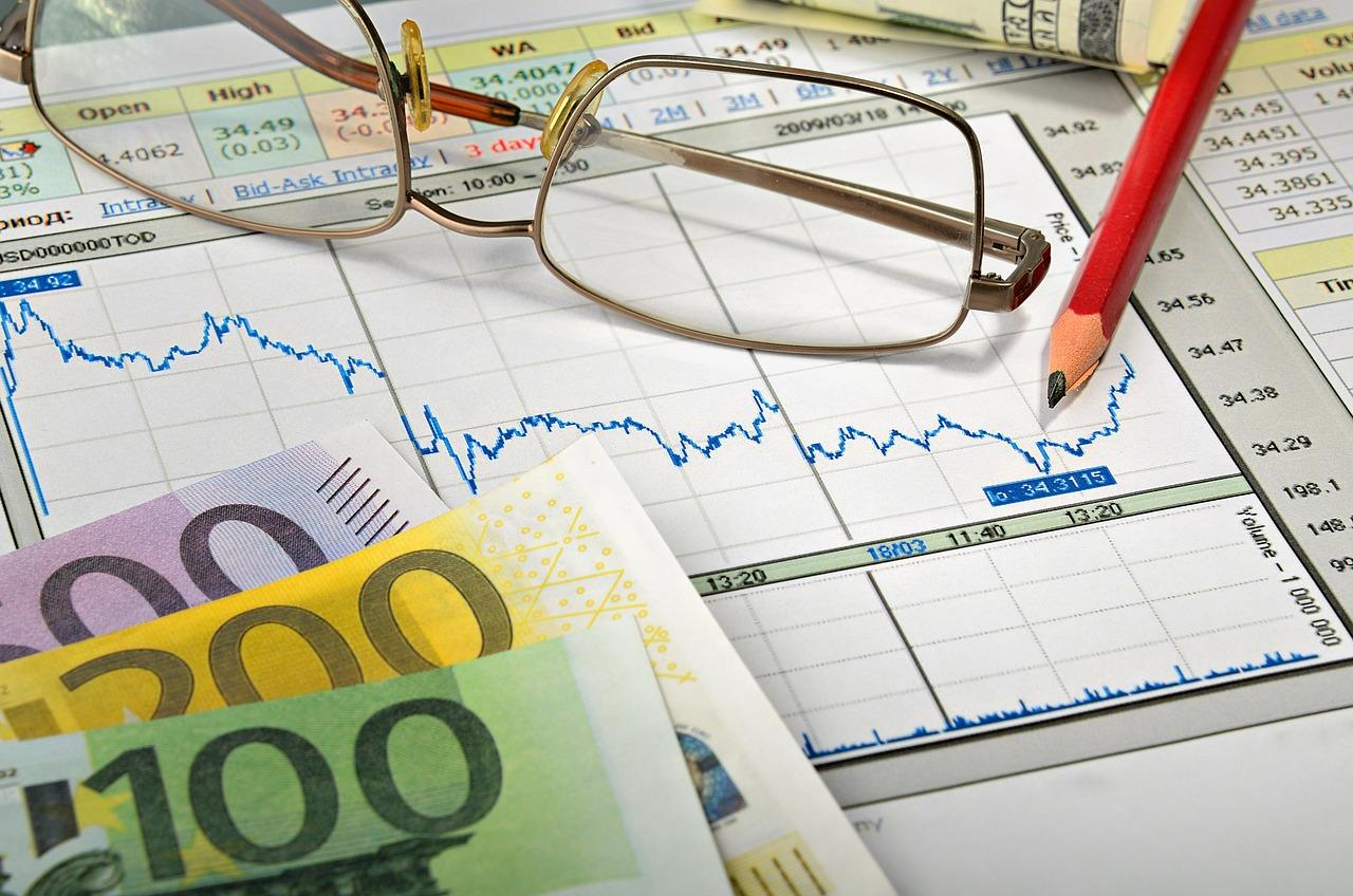 Planificador financiero con billetes de euro y bolígrafo, simbolizando el cálculo de la base reguladora de la pensión