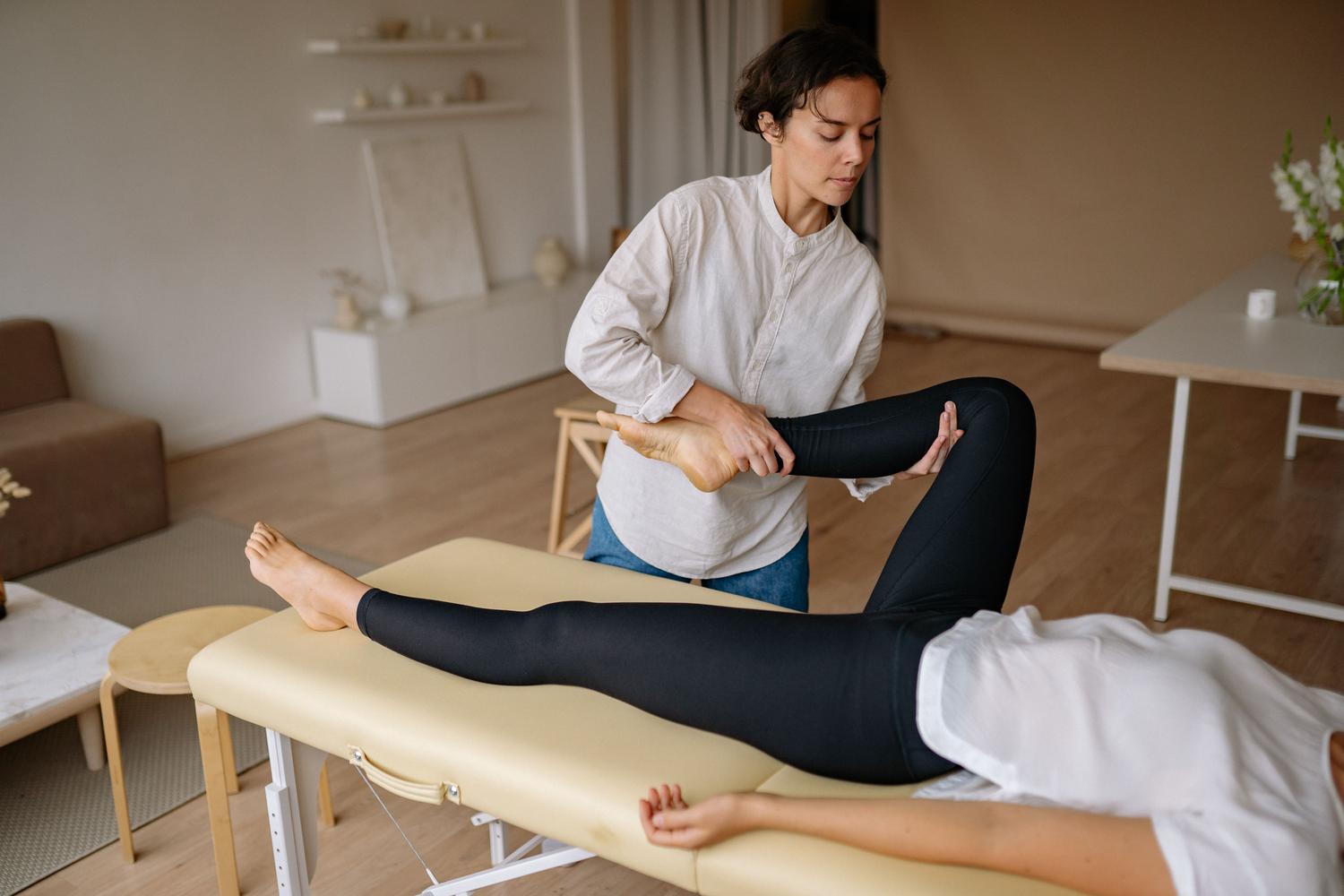 Terapeuta realizando un masaje de drenaje linfático en la pierna de un paciente para reducir el edema.