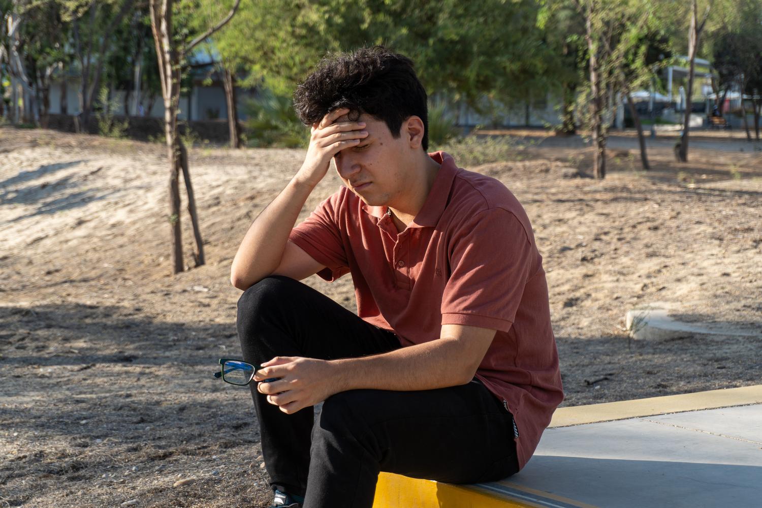 Joven adolescente con gesto de angustia y estrés, reflejando los desafíos de la salud mental en la juventud.