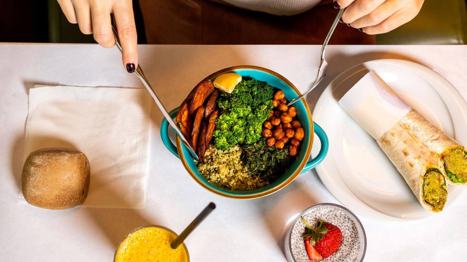Bowl vegano nutritivo con quinoa, garbanzos asados, brócoli y camote, ilustrando una comida equilibrada rica en proteínas vegetales.