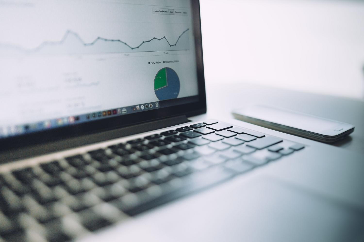 Panel de análisis de datos con gráficos y tablas en un ordenador portátil, representando la estadística descriptiva y el procesamiento de datos.