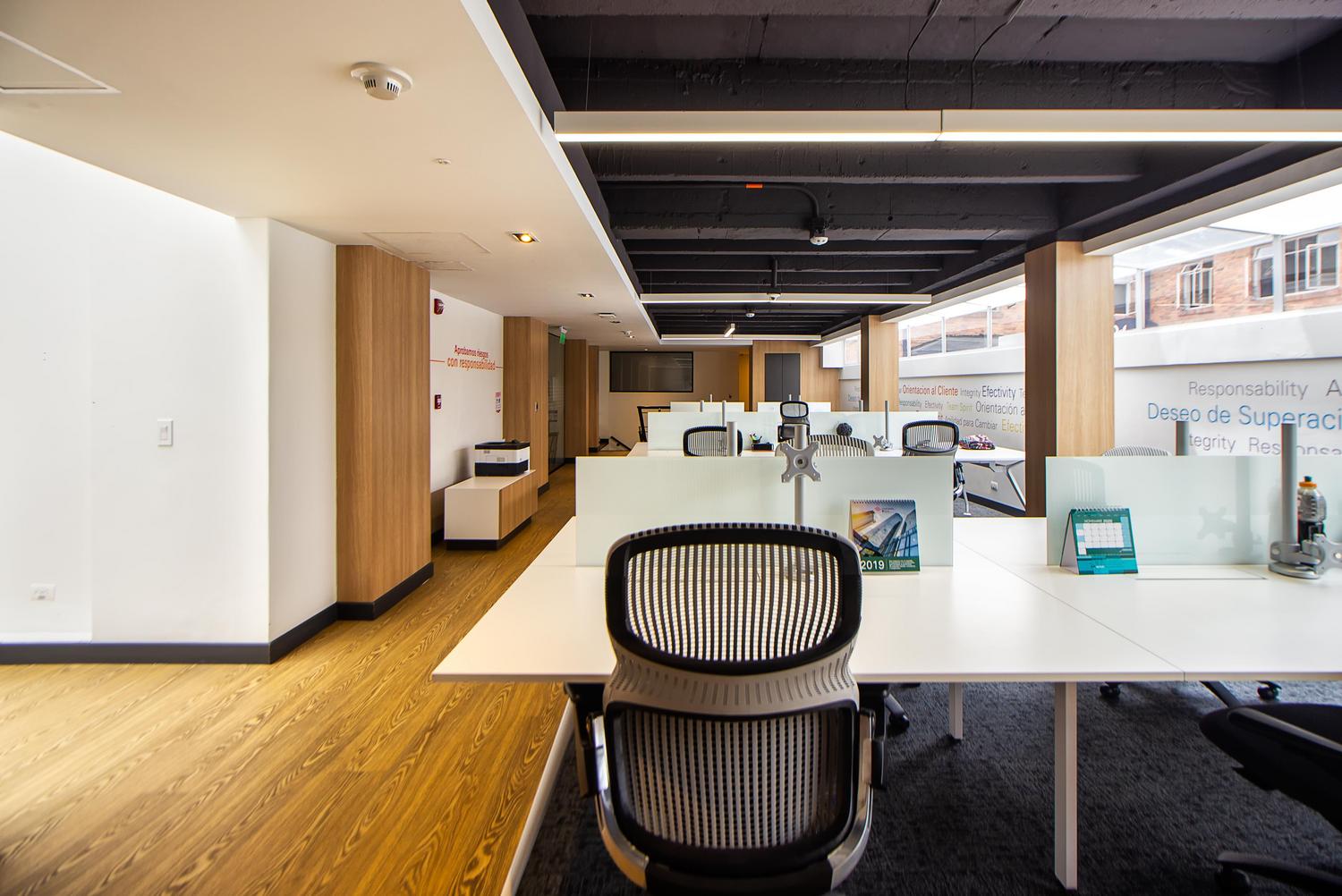 Espacio de oficina moderno de planta abierta y diseño minimalista, representando la modernización de los entornos laborales.