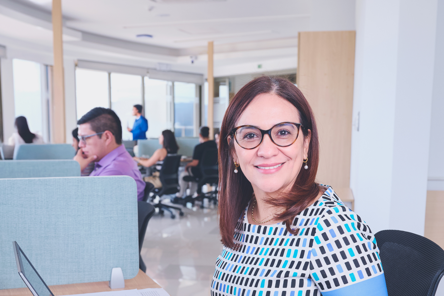 Reclutadora de personal moderna y empática sonriendo em um entorno de oficina abierta