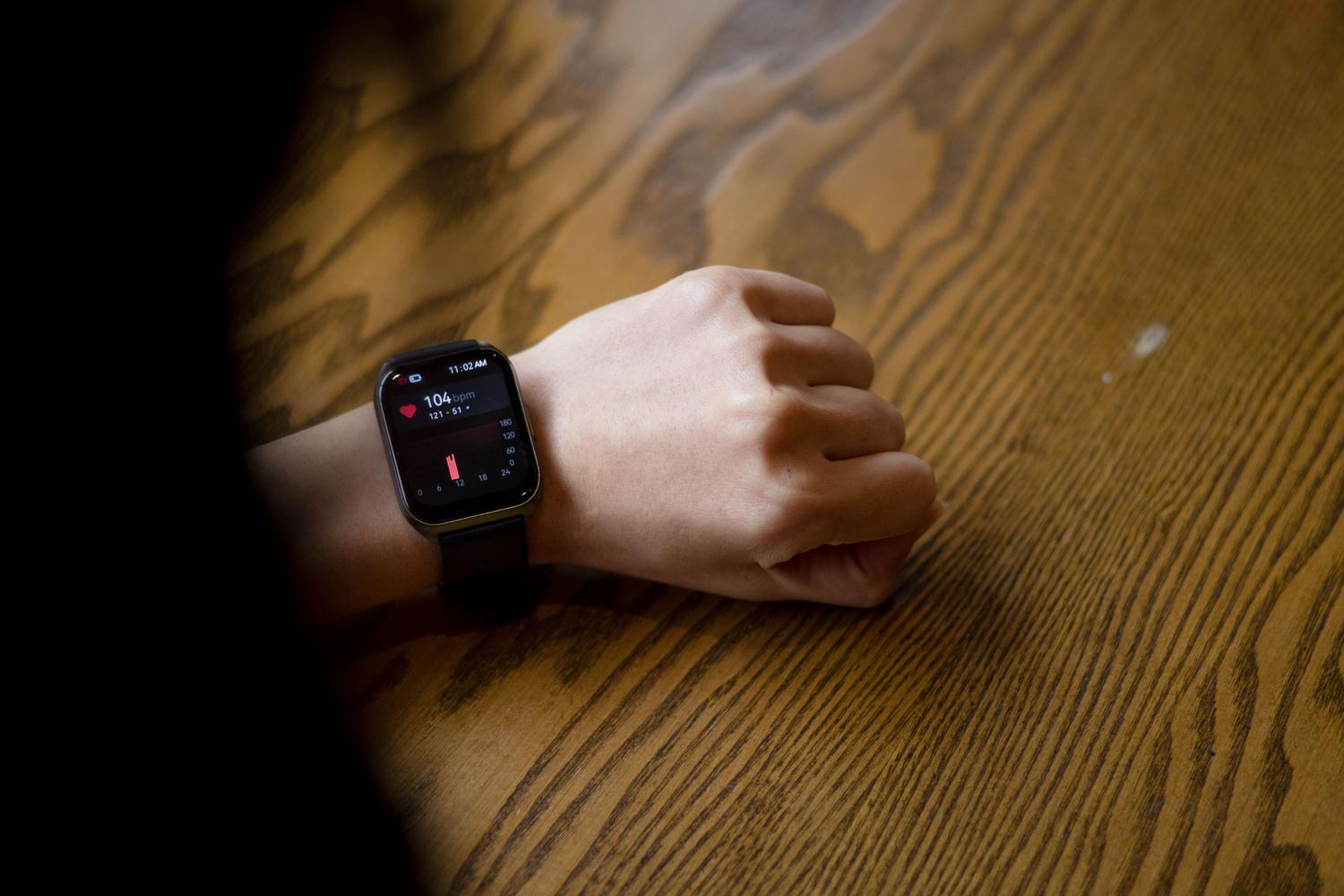 Primer plano de un reloj inteligente mostrando la frecuencia cardíaca, ilustrando el monitoreo preventivo de la fibrilación auricular.