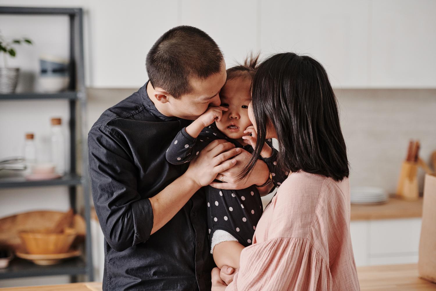 Familia compartiendo un momento de afecto en la cocina, representando los rituales familiares y el entorno seguro.