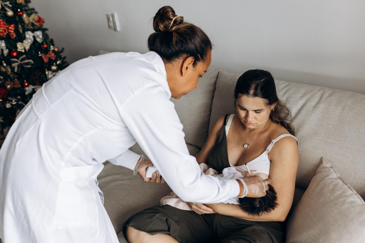 Profesional de la salud orientando a una madre sobre el cuidado y nutrición de su bebé durante una visita domiciliaria.