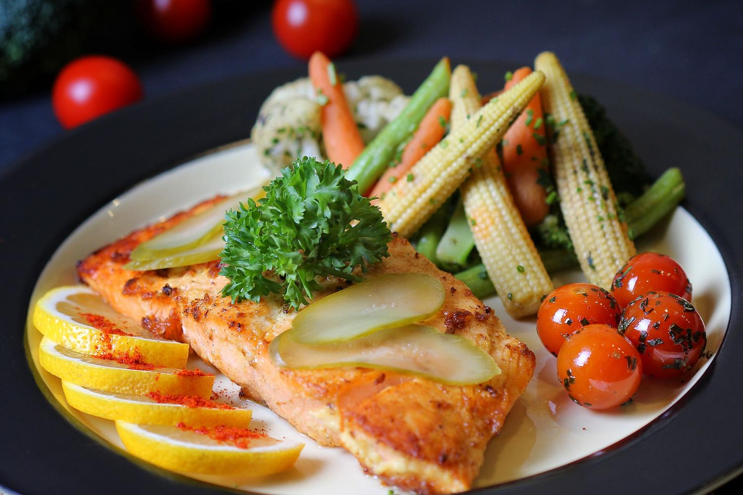 Salmón a la parrilla con vegetales al vapor y tomates cherry, una opción saciante, digestiva y nutritiva.