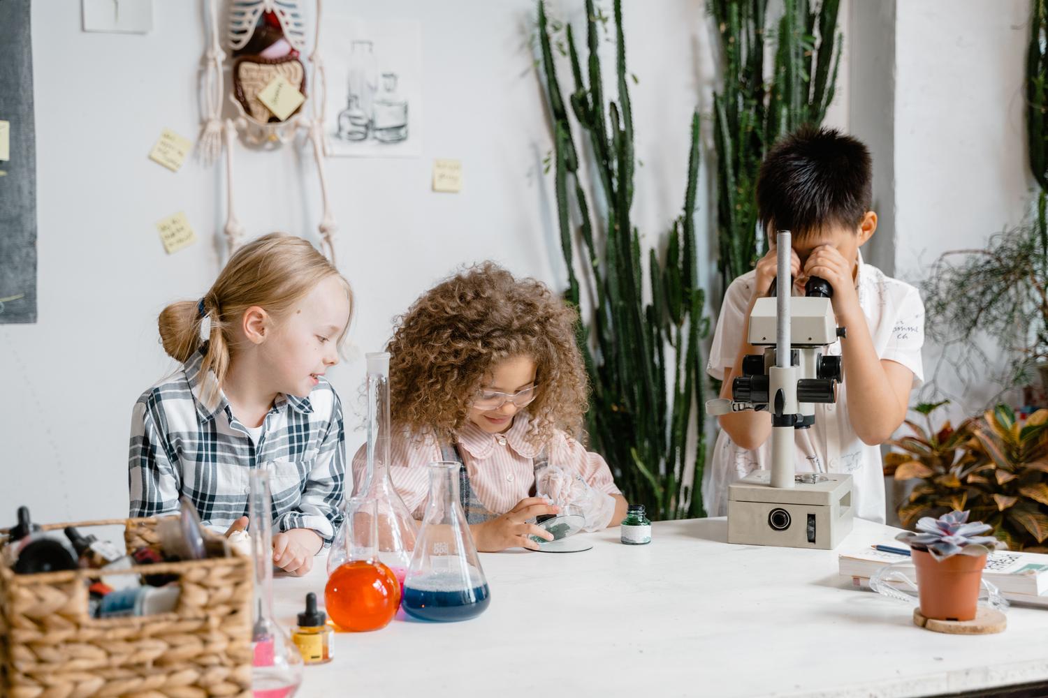 Grupo diverso de niños realizando experimentos científicos en un laboratorio escolar, fomentando el aprendizaje STEM.