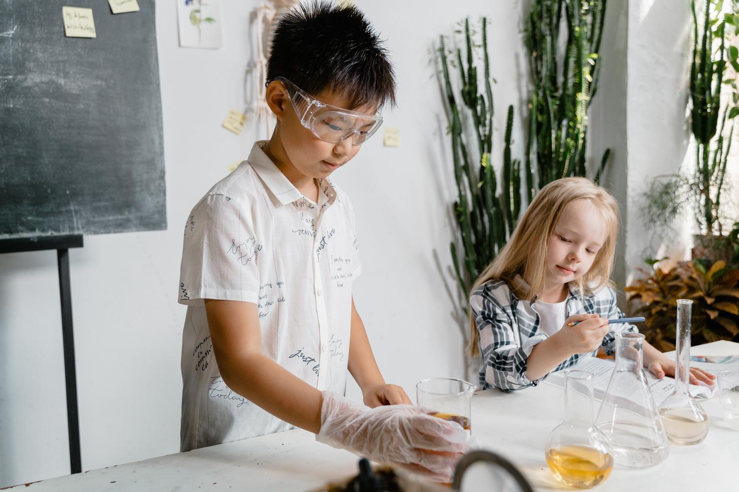 Niños curiosos realizando un experimento práctico con equipo de laboratorio científico.