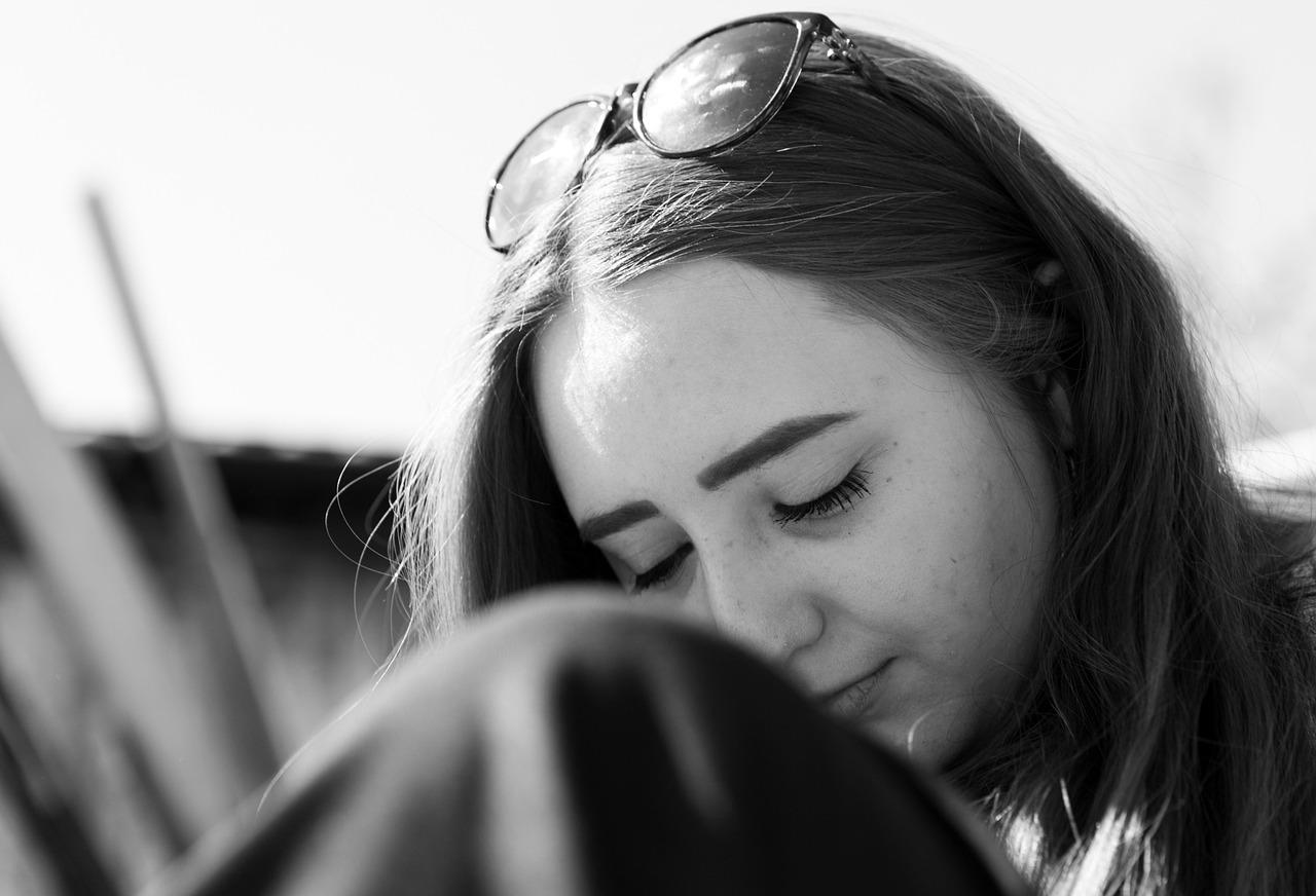 Retrato en blanco y negro de una mujer pensativa, ideal para ilustrar la reflexión personal.