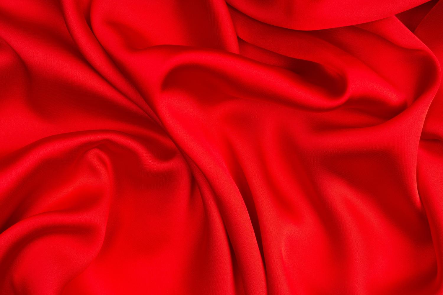 Textura de seda roja vibrante y brillante, reflejo de los tejidos opulentos que adornaban las cortes.