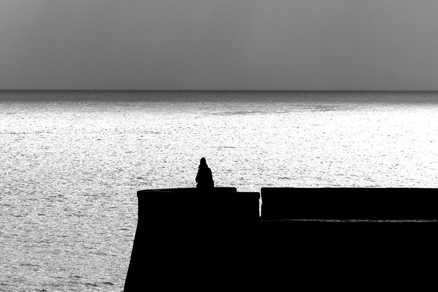 Silueta dramática en blanco y negro de una persona solitaria junto al mar, evocando la soledad como herramienta de meditación. Silueta dramática en blanco y negro de una persona solitaria junto al mar, evocando la soledad como herramienta de meditación.